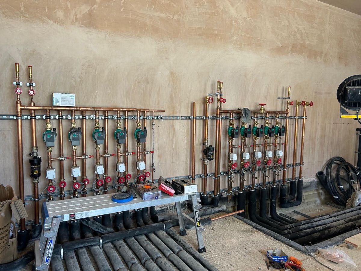 Copper heating distribution pipework, green circulation pumps and isolation valves from one of our installations
